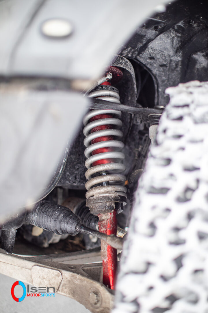 cutaway view into wheel well of installed JRZ AT suspension shock on Ford Raptor, installation by Olsen Motorsports